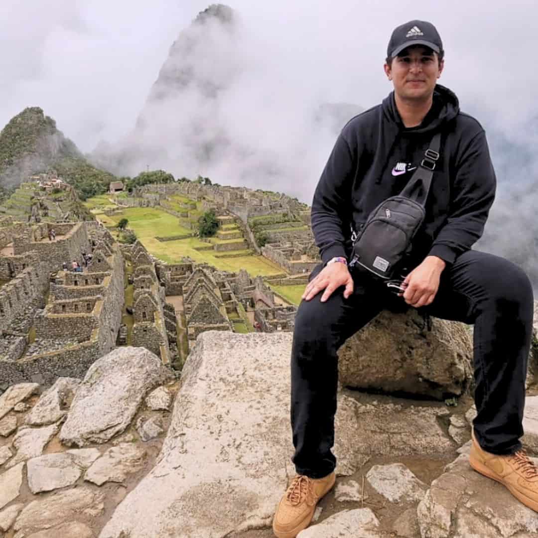 Yacin sitting in front of the iconic Machu Picchu